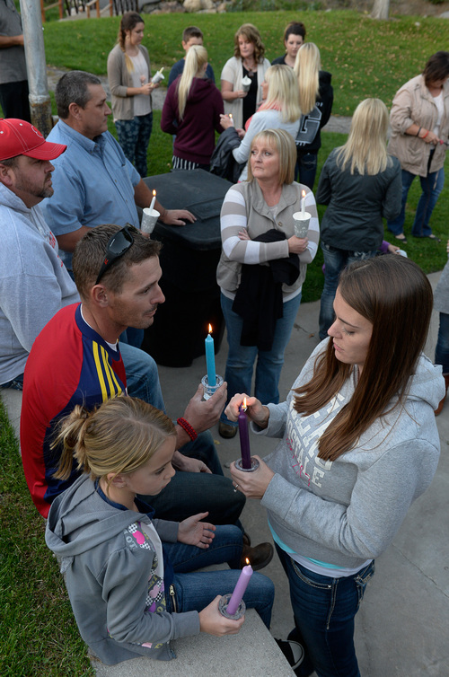 Francisco Kjolseth  |  The Salt Lake Tribune
Bret and Celia Walker, along with their daughter Boston, 6, light candles as they join other friends, family and those expressing concern during a candlelight vigil at Murray Park for Kayelyn Louder, 30, who has been missing since Sept. 27. Surveillance footage at her Murray condo shows her leaving barefoot, in just a tanktop and shorts, into a cold, rainy evening. Murray police are investigating her disappearance, while friends and family spread fliers and awareness.