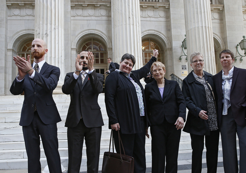 FILE - Plaintiffs challenging Utah's gay marriage ban, from left, Derek Kitchen, his partner Moudi Sbeity, Kate Call, her partner Karen Archer, Laurie Wood and her partner Kody Partridge stand together after leaving court following a hearing at the U.S. Circuit Court of Appeals in Denver, Thursday, April 10, 2014.  (AP Photo/Brennan Linsley)