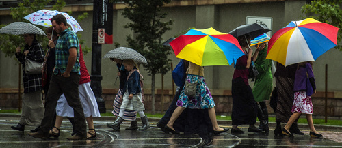 Chris Detrick  |  The Salt Lake Tribune
Pedestrians attempt to stay dry under umbrellas while crossing South Temple Street in Salt Lake City on Saturday.
