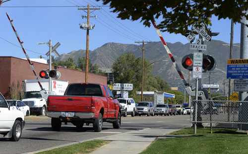 Scott Sommerdorf  |  The Salt Lake Tribune
After a TRAX train passed, motorists begin to drive under the crossing gates before the red lights have stopped flashing at the crossing signs on 2100 South on Thursday. Most people seem to not realize, but is illegal to drive through a rail crossing when gates start to rise. Drivers are supposed to wait until the red lights quit flashing, because a train in the opposite direction may re-trigger lights and lower the gates again. It's an issue that causes 250 broken gates a year for UTA, and costs $250,000 in repairs.