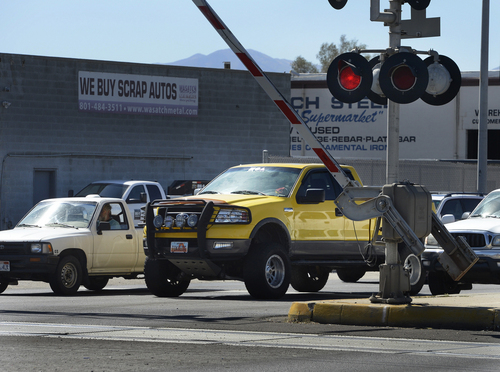 Scott Sommerdorf  |  The Salt Lake Tribune
After a TRAX train passed, motorists begin to drive under the crossing gates before the red lights have stopped flashing at the crossing signs on 3300 South, Thursday, September 25, 2014. Most people seem to not ealize, but is illegal to drive through a rail crossing when gates start to rise. Drivers are supposed to wait until the red lights quit flashing, because a train in the opposite direction may re-trigger lights and lower the gates again. It's an issue that causes 250 broken gates a year for UTA, and costs $250,000 in repairs.