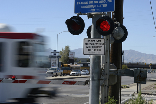 Scott Sommerdorf  |  The Salt Lake Tribune
A TRAX train blurs by as motorists wait at the crossing signs on 3300 South, Thursday, September 25, 2014. Most people seem to not realize, but is illegal to drive through a rail crossing when gates start to rise. Drivers are supposed to wait until the red lights quit flashing, because a train in the opposite direction may re-trigger lights and lower the gates again. It's an issue that causes 250 broken gates a year for UTA, and costs $250,000 in repairs.