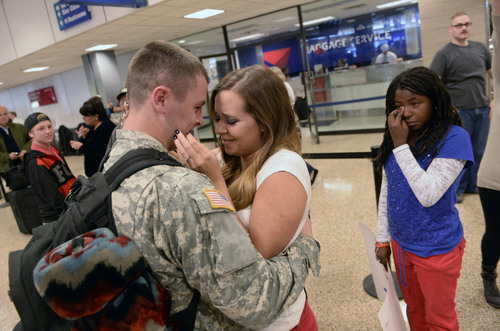 Al Hartmann  |  The Salt Lake Tribune
Halee Roberts kisses her husband Specialist Kendrick Roberts upon his arrival at the Salt Lake City International Airport Monday Ocotber 13, 2014.  They married in September 2013 but he was deployed two months later.  The newlyweds have some catching up to do. They are from American Fork. 
 Fifty-two soldiers from two Utah National Guard units returned from Kosovo and Afghanistan on Monday. Forty-five soldiers returned from the 2nd Battalion, 211th Aviation from an 11-month deployment to Kosovo and seven soldiers from the 142nd Military Intelligence Battalion, after a seven-month deployment in Afghanistan.