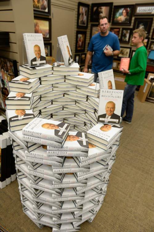 Francisco Kjolseth  |  The Salt Lake Tribune
Stacks of books greet visitors as Jon Huntsman Sr., signs copies of his new autobiography, "Barefoot to Billionaire," at a book signing at Deseret Book in downtown Salt Lake City on Friday, Oct. 3. 2014.