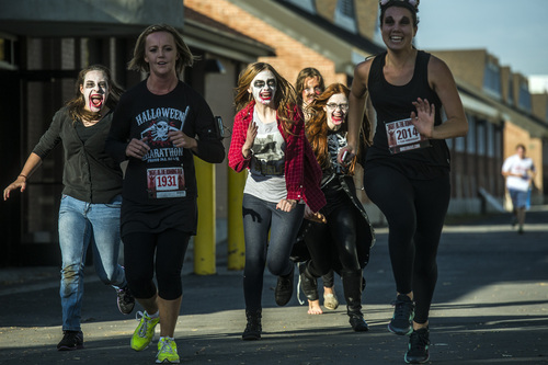 Chris Detrick  |  The Salt Lake Tribune
Zombies Faith Hilton, Emily Butler, Ruth Evans and Lucy Hill chase humans Kristy Deans, left, and Lauren Vail during the Dawn of the Running Dead 5K race at the Utah State Fairpark on Saturday.