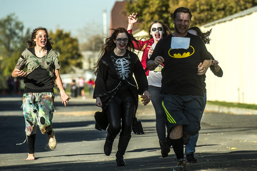 Chris Detrick  |  The Salt Lake Tribune
Zombies Ruth Evans, Lucy Hill, Emily Butler and Faith Hilton chase human Sean Cupe, of Ogden, during the Dawn of the Running Dead 5K race at the Utah State Fairpark Saturday October 18, 2014.