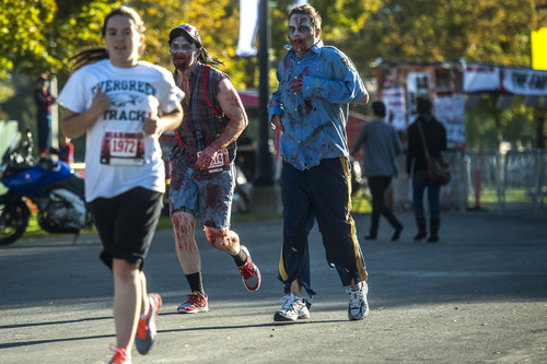 Chris Detrick  |  The Salt Lake Tribune
Zombies Cameron Romine, of Eagle Mountain, and Tyler Lloyd, of South Jordan, chase down humans during the Dawn of the Running Dead 5K race at the Utah State Fairpark Saturday October 18, 2014.