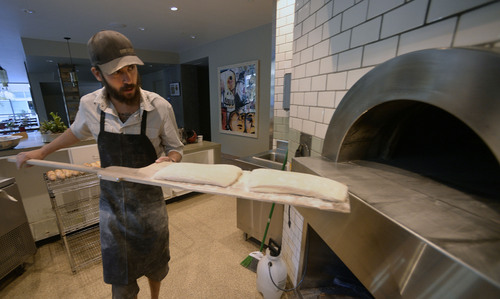 Al Hartmann  |  The Salt Lake Tribune
Ryan Moore, bread baker at From Scratch, loads dough for ciabata bread into the wood-fired pizza oven.  The loaves are used in the restaurant and extras are sold. The restaurant is the only one in the Salt Lake Valley that grinds its own wheat on-site and sells bread baked from the hearth oven. Moore is one of 15 bakers selected to try out for a spot on the Team USA culinary team.