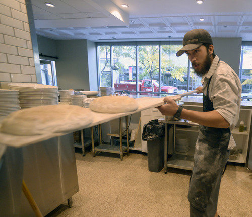 Al Hartmann  |  The Salt Lake Tribune
Ryan Moore, bread baker at From Scratch, loads dough for ciabata bread into the wood-fired pizza oven.  The loaves are used in the restaurant and extras are sold. The restaurant is the only one in the Salt Lake Valley that grinds its own wheat on-site and sells bread baked from the hearth oven. Moore is one of 15 bakers selected to try out for a spot on the Team USA culinary team.