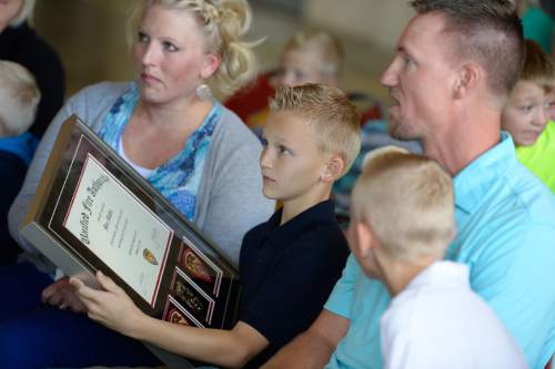 Francisco Kjolseth  |  The Salt Lake Tribune
Unified Fire Authority recognizes 10-year old Max Moffat center, for his quick action in rescuing his 5-year old brother Miles from a potential near drowning incident this summer. Also pictured are his parents Heather and Richard along with his brother Carter, 12. The event took place on July 18 at the Fox Point Old Farm Apartment Complex when Max was able to locate and bring Miles to the surface after the 5-year old slipped under water at a swimming party.