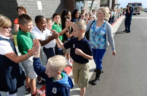 Francisco Kjolseth  |  The Salt Lake Tribune
Fellow students from Ascent Academy in West Jordan give 10-year old Max Moffat, center, high fives after arriving by fire engine with his brother Miles, 5, and mother Heather on Tuesday morning. Max was being recognized by Unified Fire Authority for his quick action in rescuing his 5-year old brother Miles from a potential near drowning incident this summer. The event took place on July 18 at the Fox Point Old Farm Apartment Complex when Max was able to locate and bring Miles to the surface after the 5-year old slipped under water at a swimming party.