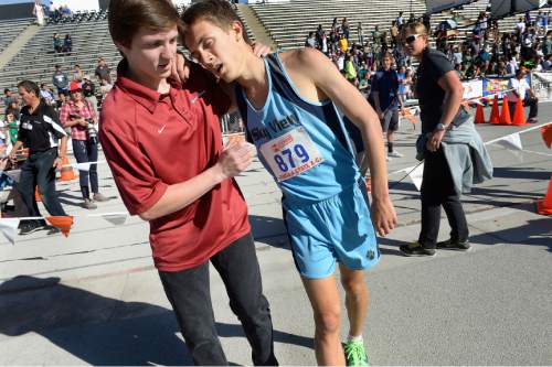 Scott Sommerdorf  |  The Salt Lake Tribune
An exhausted Conner Mantz is helped from the finish line after he collapsed just 20 meters from the finish line in the boys' 4A race at the Utah State cross-country races held at Sugar House Park and Highland H.S., Wednesday, October 22, 2014.