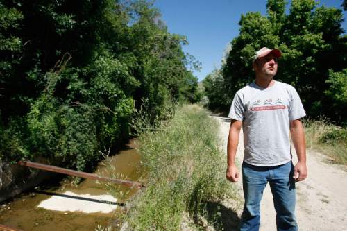 Sean Bartschi, 30, walks along the Logan Northern Canal pointing out cracks and other deterioration above Canyon Road in Logan on  Tuesday July 14, 2009. Bartschi's home was damaged in Saturday's mudslide. 

Photo by Chris Detrick/The Salt Lake Tribune