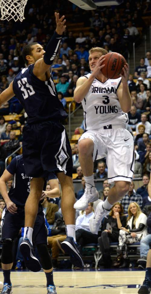 Rick Egan  | The Salt Lake Tribune 

Brigham Young Cougars guard Tyler Haws (3) goes under the hoop for a shot as San Diego Toreros forward/center Jito Kok (33) defends, in basketball action,  BYU vs. The San Diego Toreros at the Marriott Center,  Saturday, January 4, 2014.
