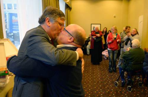 Steve Griffin  |  The Salt Lake Tribune


Gage Church, left, and his husband, Tim Sharp, embrace and kiss they are announced husband and husband Father Robert Trujillo, of Glory To God Old Catholic Church, at the Hampton Inn Suites in Ogden, Utah Monday, December 23, 2013. Volunteer clergy were performing marriage ceremonies for couples across the street from the Weber County Clerk's Office in downtown Ogden.