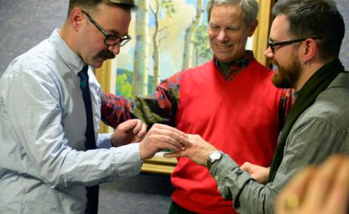 Keith Johnson | The Salt Lake Tribune

Mark Hofeling, left, exchanges rings with new husband Jesse Walker while being married by Salt Lake City Mayor Ralph Becker outside the Salt Lake County clerks office, Friday, December 20, 2013. A federal judge in Utah Friday struck down the state's ban on same-sex marriage, saying the law violates the U.S. Constitution's guarantees of equal protection and due process.