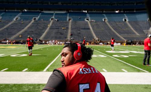 Jeremy Harmon  |  The Salt Lake Tribune

Offensive linesman Isaac Asiata (54) sits on the sidelines before before Utah faces Michigan in Ann Arbor, Saturday, Sept. 20, 2014.