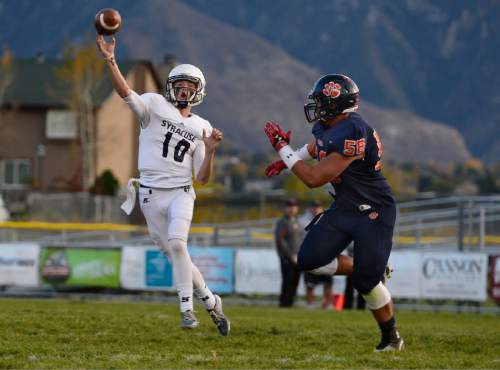 Scott Sommerdorf  |  The Salt Lake Tribune
Syracuse WR Chase Bauerle throws back to QB Kole Tracy on a trick play during second half play. Brighton beat Syracuse 35-14 in a 5A first-round playoff game at Brighton, Friday, October 31, 2014.