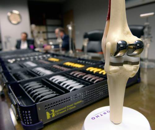 Al Hartmann  |  The Salt Lake Tribune
Doctors Marc Mariani and Michael Bourne of Salt Lake Orthopaedics Clinic helped Ortho Development Co. of Draper invent knee implants for their balanced knee system. Besides the implants specialized system tools (seen on the table) were developed.   Almost all the money they get from Ortho is in royalties for the inventions. The two, however, get no royalties for any of those devices they implant or that are implanted by their colleagues or other doctors at St. Mark's.