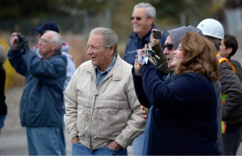 Al Hartmann  |  The Salt Lake Tribune
Cottonwood Heights residents watch and take pictures as a backhoe begins the demolition of one of eight homes Monday, Nov. 3, 2014, that will make way for a new city hall at 7550 S. 2300 East.