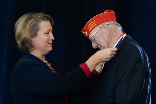 Francisco Kjolseth  |  The Salt Lake Tribune
Ruth Watkins, senior vice president for academic affairs at the University of Utah, places a medal on William "Bill" Baucom, a veteran of the Korean War, during the annual Veterans Day ceremony where it 11 Utah veterans were honored during a ceremony at the Olpin Union Building.