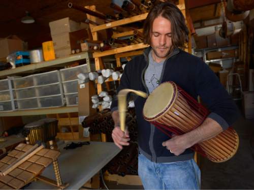 Leah Hogsten  |  The Salt Lake Tribune
Andy Jones plays a "talking drum" that changes pitch with the manipulation of the drum's strings, October 30, 2014, in the Africa Heartwood Project warehouse in Salt Lake City. The Africa Heartwood Project is a grass-roots nonprofit seeking to redress causes and symptoms of poverty in West Africa.  Jones works with dozens of cultural artisans in the countries of Ghana, Mali, Guinea, Senegal and the Ivory Coast to ensure sustainability of their livelihoods through training, micro-credit, and access to international fair-trade markets.