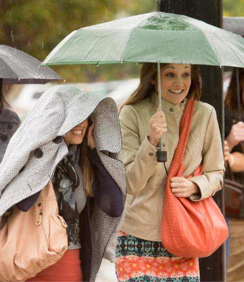 Rick Egan  |  The Salt Lake Tribune

Kerri Johnson, and Cammie Dickerson, try to keep dry as they make their way to the to the LDS Conference Center, for Women's Conference, Saturday, September 27, 2014.