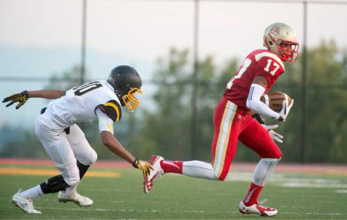 Rick Egan  |  The Salt Lake Tribune

Xavier Price (17) runs for Judge Memorial, as Everet Miller (10) defends for Union, in prep football action at Judge Memorial, Friday, September 19, 2014