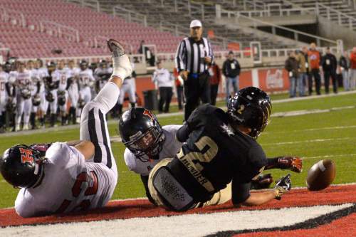 Chris Detrick  |  The Salt Lake Tribune
Desert Hills' Mason Palmer (2) can't hold onto a touchdown pass while being covered by Hurricane's Charlie Sefita (52) and Hurricane's Dylan Tisdale (65) during the 3AA state football semifinal game at Rice-Eccles Stadium Friday November 14, 2014.