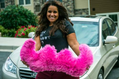 Chris Detrick  |  The Salt Lake Tribune
Angie Palmer poses for a portrait with her car in Midvale Thursday August 7, 2014.  Salt Lake City is issuing $6,500 tickets to drivers for the ridesharing services Lyft and Uber, contending they essentially are illegal taxi operations.