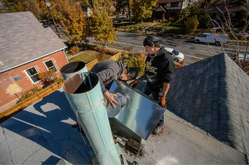 Trent Nelson  |  The Salt Lake Tribune
Tyler Marquardt and Ben Loya replace two old chimney pipes with a new vent while installing a gas fireplace at a home in Salt Lake City, Tuesday November 11, 2014.