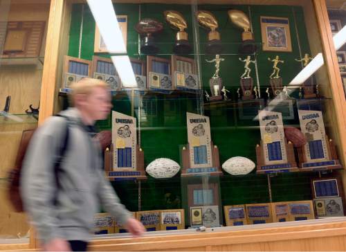 Al Hartmann  |  The Salt Lake Tribune
Bingham HIgh School student walks past the full case of football state championship trophies and balls.  The school has become a football dynasty under head coach Dave Peck's tenure.