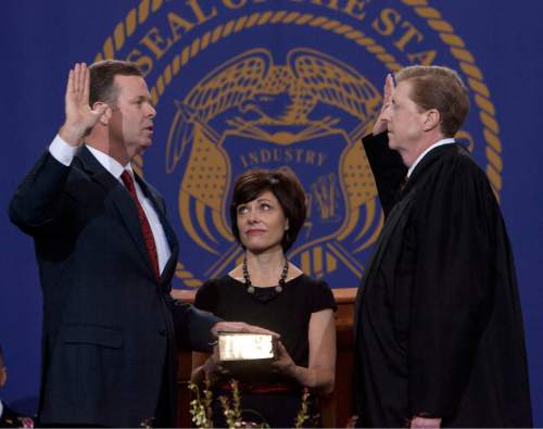 Steve Griffin | The Salt Lake Tribune

Attorney General John Swallow, left,  is sworn in by Chief Justice Matthew B. Durrant as his wife, Suzanne, holds the bible during inauguration ceremnoy at the Utah State Capitol  in Salt Lake City, Utah Monday January 7, 2013.