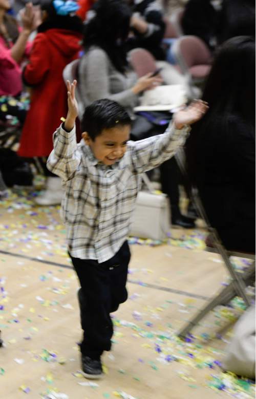 Francisco Kjolseth  |  The Salt Lake Tribune
Brian Soledad, 4, plays with confetti as the family gathered to watch the news at Centro Civico Mexicano from the White House during the historic announcement by President Barack Obama to transform immigration policy and spare 5 million from deportation.