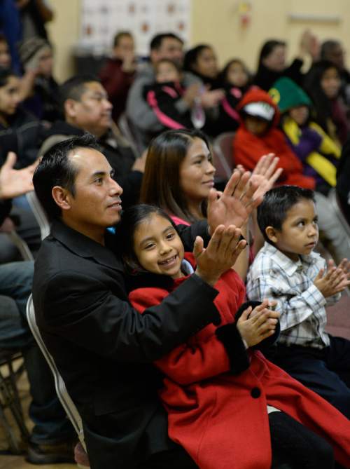 Francisco Kjolseth  |  The Salt Lake Tribune
Javier Soledad and his wife Silvia Ramirez are joined by their children Leslie, 7, and Brian, 4, as they cheer the news being broadcasted at Centro Civico Mexicano from the White House of the historic announcement by President Barack Obama to transform immigration policy and spare 5 million from deportation.