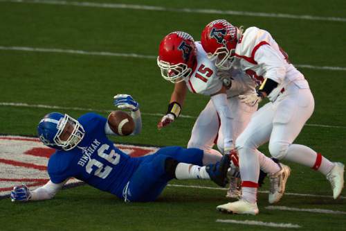 Chris Detrick  |  The Salt Lake Tribune
Bingham's Cameron Smith (26) is tackled by American Fork's J Worley (15)  and American Fork's Ben Cummings (20), causing a fumble, during the 5A state championship game at Rice-Eccles Stadium Friday November 21, 2014.