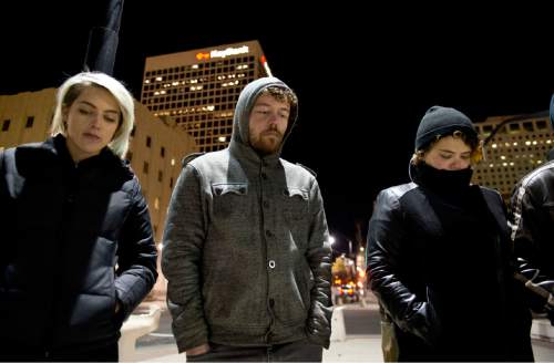 Lennie Mahler  |  The Salt Lake Tribune
Gabriella Andersson, Greg Murray and Jessica Arter observe a moment of silence after a Ferguson, Mo., grand jury ruled not to file criminal charges against officer Darren Wilson for the death of Michael Brown. The rally was held in front of the Wallace F. Bennett Federal Building in downtown Salt Lake City.