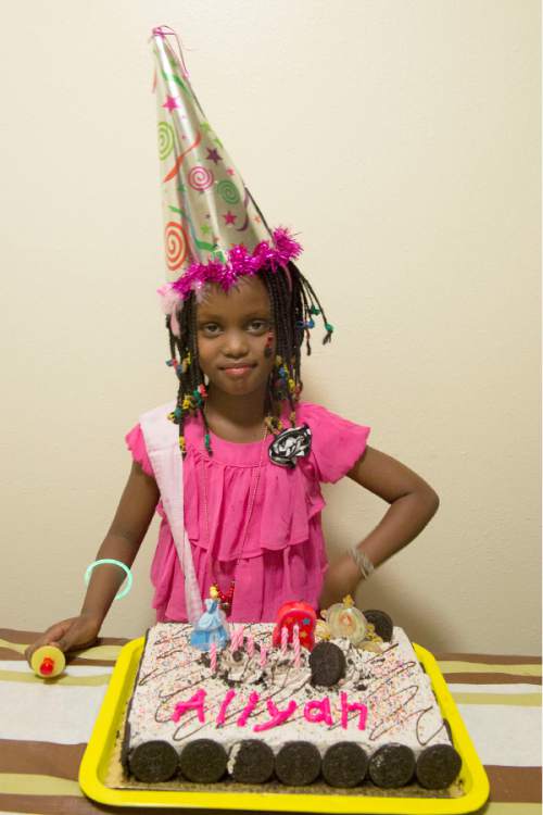 Rick Egan  |  The Salt Lake Tribune

Alia Bugingo celebrates her 8th birthday in her family's apartment in Rose Parkon Aug. 17, 2014.