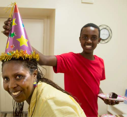 Rick Egan  |  The Salt Lake Tribune

Philip puts a birthday hat on Godelive, his mother, during Aliyah's birthday party, at their apartment in Rose Park on Aug. 17, 2014.
