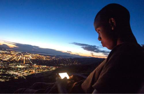 Rick Egan  |  The Salt Lake Tribune

Philip Bugingo, 16, plays games on his phone while taking a rest during a hike overlooking Salt Lake City on Sept. 17, 2014.