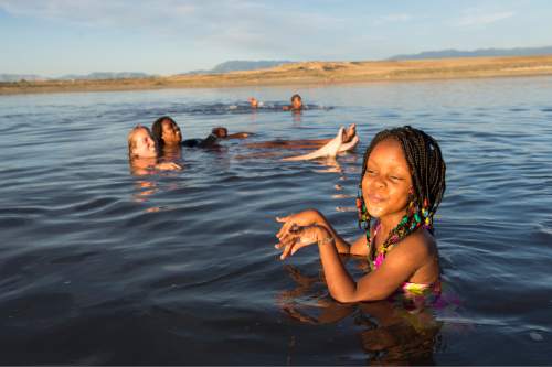 Rick Egan  |  The Salt Lake Tribune

Alia Bugingo (front) swims with her family and friends in the Great Salt Lakeon Aug. 15, 2014.
