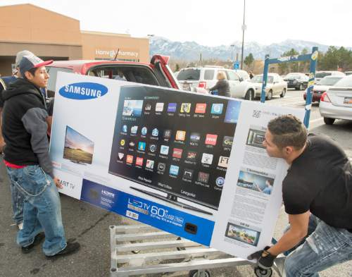 Rick Egan  |  The Salt Lake Tribune

Ever Hernandez lifts the new 60-inch TV  he bought on a Black Friday deal, with the help of his brother, Yuviny Hernandez, Friday, November 28, 2014