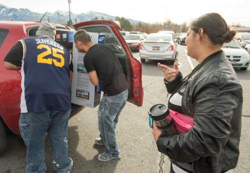 Rick Egan  |  The Salt Lake Tribune

Keidy Hernandez crosses her fingers as her husband Ever Hernandez and his brother Yuviney try to fit their new 60-inchTV the bought on Black Friday into their car, Friday, November 28, 2014