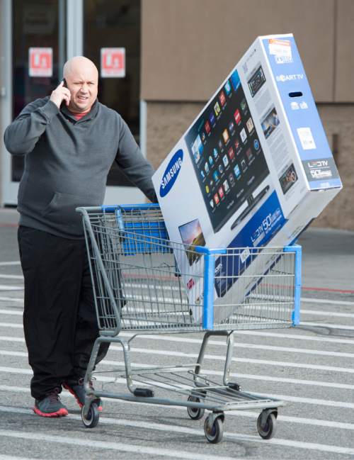 Rick Egan  |  The Salt Lake Tribune

Ryan Ault wheels a TV out to his car, that he picked up on a Black Friday deal. Friday, November 28, 2014
