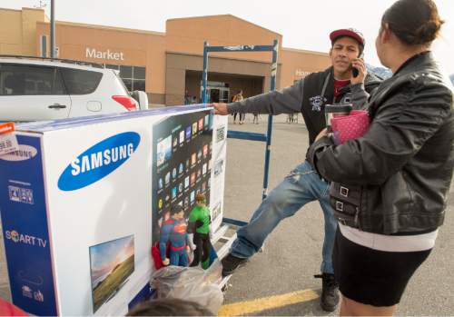 Rick Egan  |  The Salt Lake Tribune

Ever and Keidy Hernandez call for a relative to meet them at Walmart, because they found a great Black Friday deal on a 60-inch TV, and it would not fit in their car, Friday, November 28, 2014