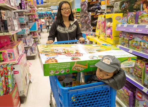 Rick Egan  |  The Salt Lake Tribune

Xue Song shops with three-year -old Benjamin Hao at Toys R Us in Sugar House after the 4:50 p.m. opening, Thursday, November 27, 2014.