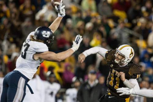 Wyoming quarterback Colby Kirkegaard has a pass blocked by Utah State's Zach Vigil in the fourth quarter of an NCAA college football game Friday, Nov. 7, 2014, in Laramie, Wyo. Utah State won 20-3. (AP Photo/Casper Star-Tribune, Ryan Dorgan)
