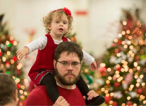 Rick Egan  |  The Salt Lake Tribune

Arianna Carlton, 2, Ogden, rides on the shoulders of her dad Chris, at the Festival of Trees at the South Towne Expo Center, Thursday, December 4, 2014. The Festival continues from 10 am to 10 pm until December 6.