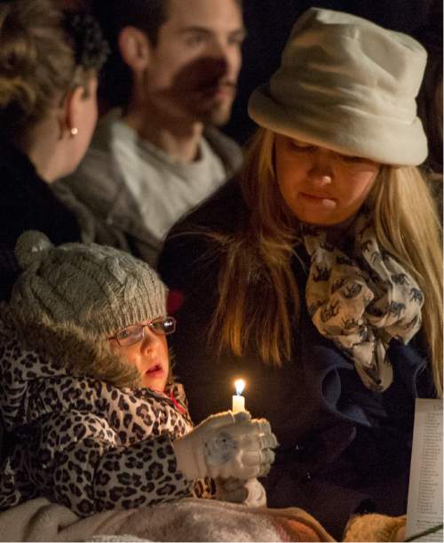 Rick Egan  |  The Salt Lake Tribune

Daphne Green, 5, holds a candle as she sits by her mom Melanie, during the annual ceremony for grieving parents at the Christmas Box Angel, at the Salt Lake City Cemetery, Saturday, December 6, 2014