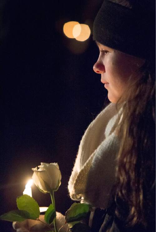 Rick Egan  |  The Salt Lake Tribune

Skyler Jordan, 13, holds a candle and a white rose, during the annual ceremony for grieving parents at the Christmas Box Angel, at the Salt Lake City Cemetery, Saturday, December 6, 2014